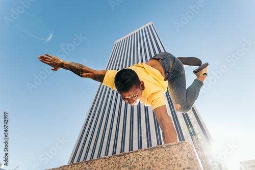 Gymnast doing a handstand in an urban area with skyscrapers