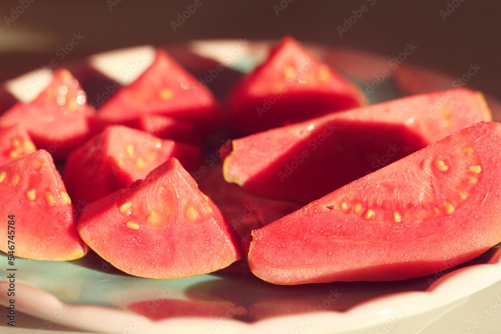 close up of red guava slices in a plate close up of red guava slices in a plate