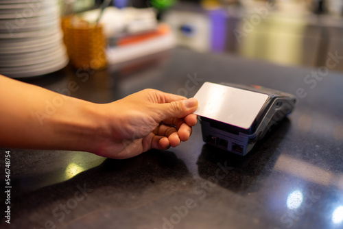 Customer making wireless or contactless payment using credit card. Cashier accepting payment over nfc technology.