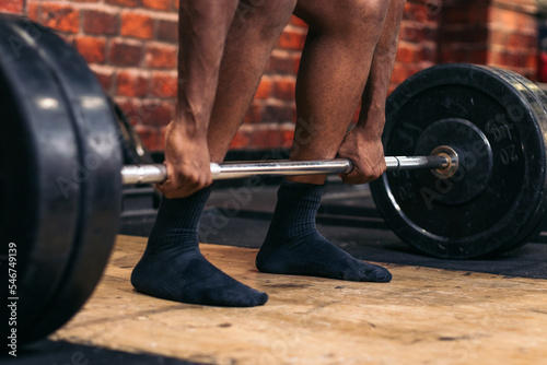 Unrecognizable man training deadlift in the gym photo
