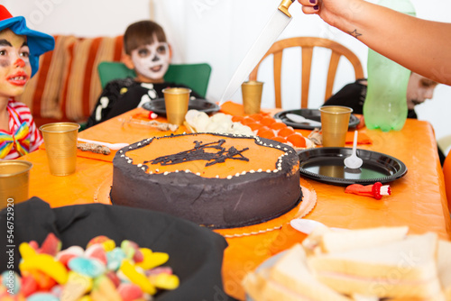 excited kids wait for halloween party cake to be cut photo