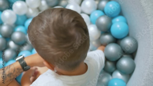 closeup shot of a little Caucasian boy enjoying in the little balls at the nursery. High quality 4k footage photo