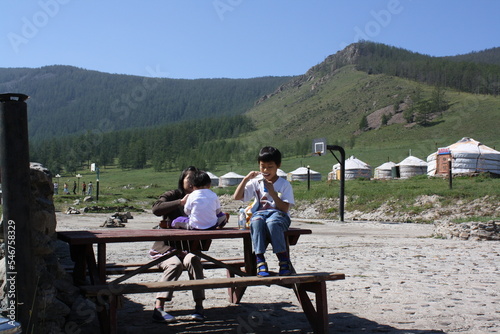 A family picnic in the desolate Bogd Khaan valley, Ulaanbaatar, Mongolia. The children are joyful to spend time in the vast and tranquil valley. There are some nomadic families around the valley.