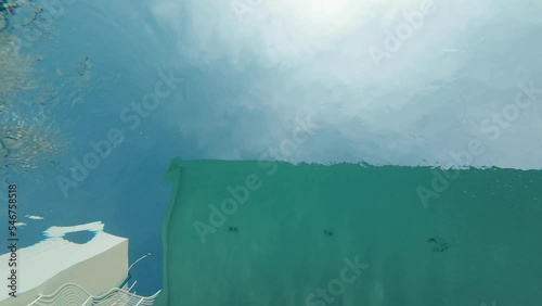 Woman swims above the camera underwater