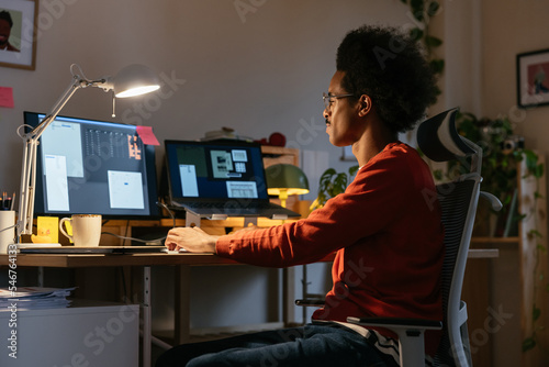 Mixed race freelancer browsing data at night photo