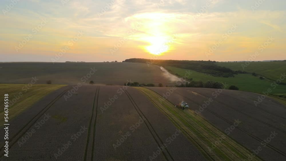 Aerial view of combine harvester working during harvesting season on large ripe wheat field. Agriculture concept Aerial view of combine harvester working during harvesting season on large ripe wheat field. Agriculture concept
