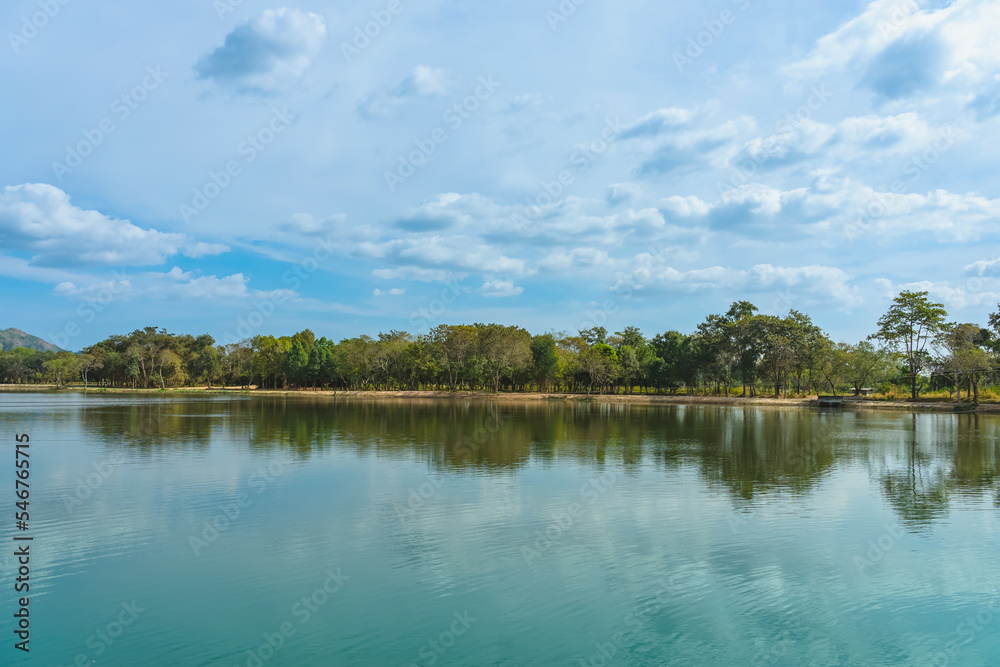 Beautiful and peaceful view of large reservoir with surrounding mountain and trees in beautiful sunshine and cloudy sky in Thailand. Tranquil and beautiful natural scenery landscape of reservoir lake. Beautiful and peaceful view of large reservoir with surrounding mountain and trees in beautiful sunshine and cloudy sky in Thailand. Tranquil and beautiful natural scenery landscape of reservoir lake.