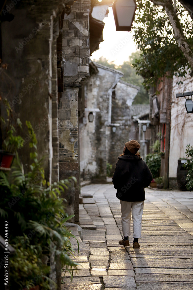 Asian woman walking on the stone road in the ancient Chinese town Asian woman walking on the stone road in the ancient Chinese town