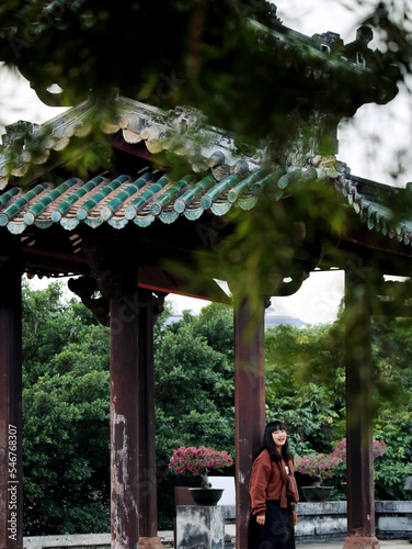 The Asian lady is under the pavilion of the ancient building

 photo