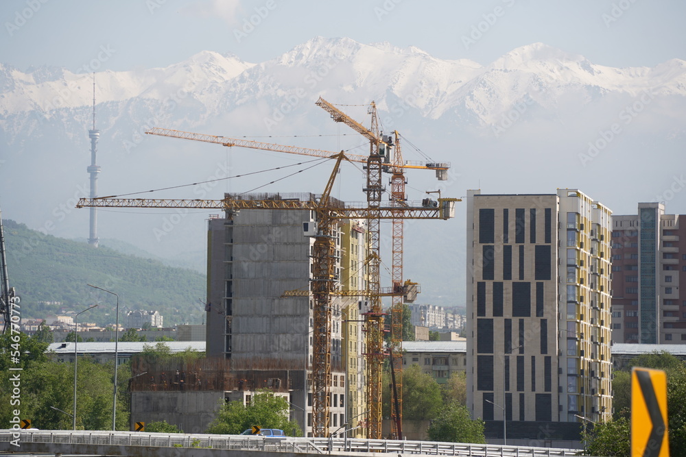 Almaty, Kazakhstan - 04.26.2022 : Construction of a high-rise residential complex near a road junction. Almaty, Kazakhstan - 04.26.2022 : Construction of a high-rise residential complex near a road junction.