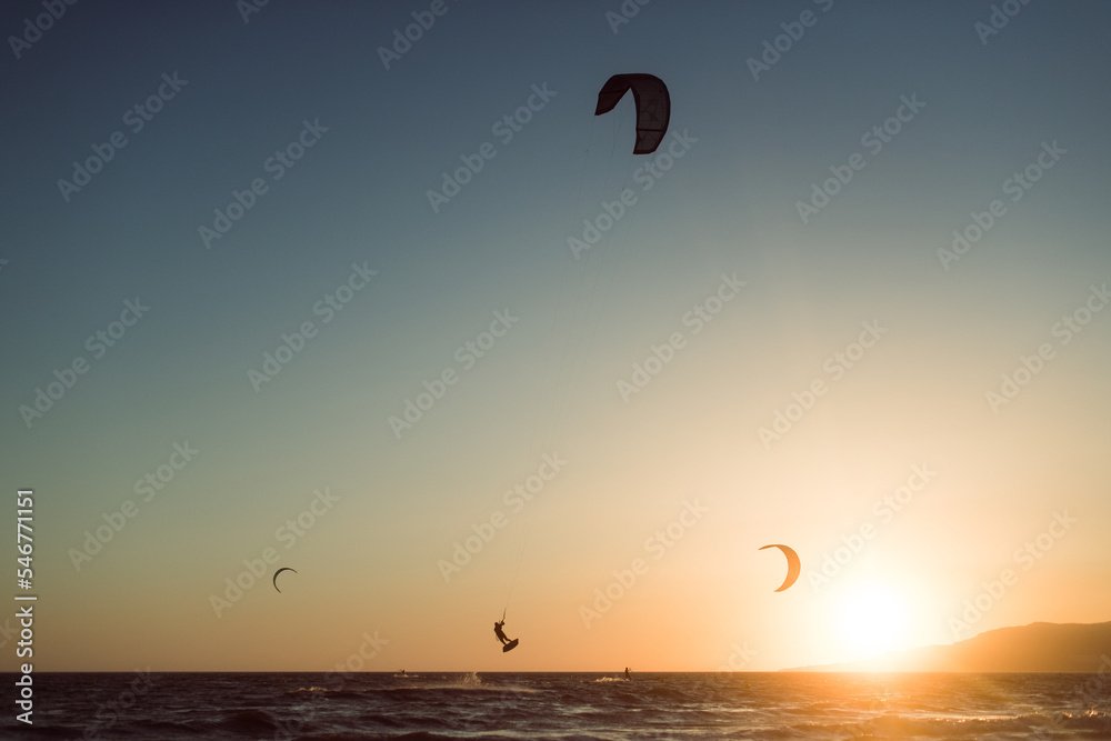 Man silhouette practicing kitesurf at sunset Man silhouette practicing kitesurf at sunset