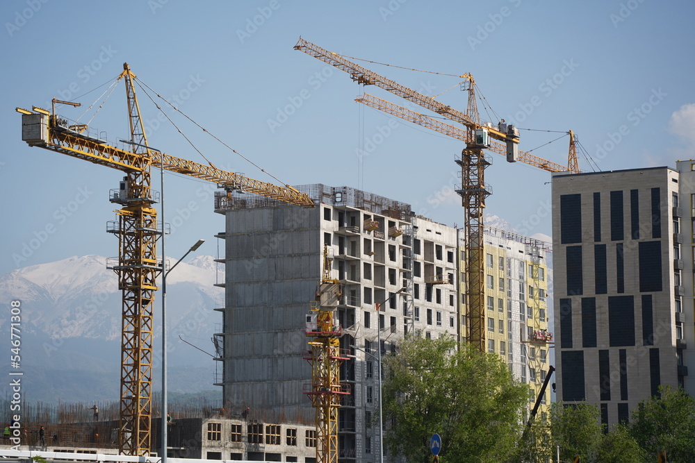 Almaty, Kazakhstan - 04.26.2022 : Construction of a high-rise residential complex near a road junction. Almaty, Kazakhstan - 04.26.2022 : Construction of a high-rise residential complex near a road junction.