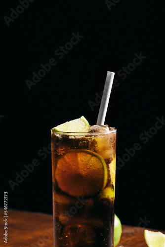 Photography Cuba libre cocktail cold and refreshing drink for summer days on a wooden table
