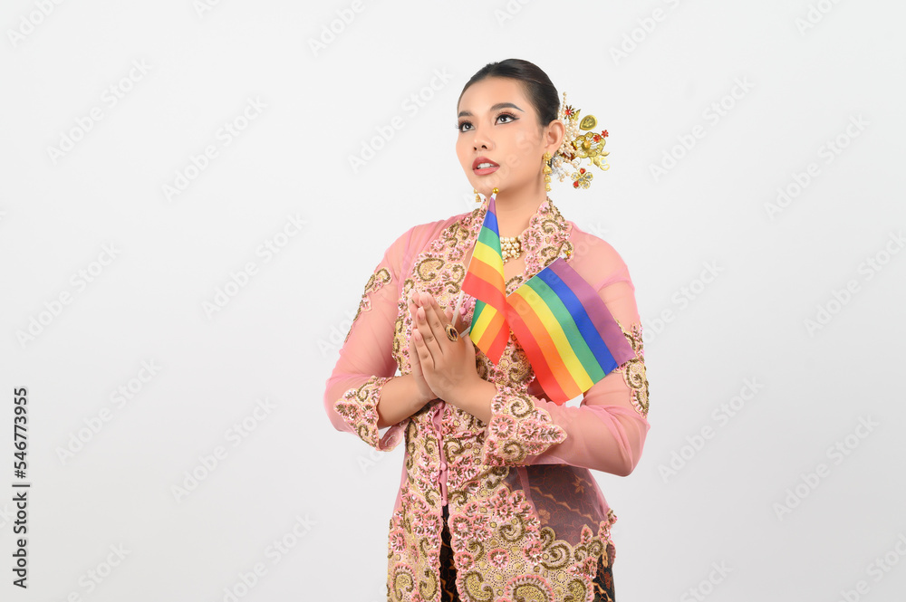 Young beautiful woman dress up in local culture in southern region with rainbow flag Young beautiful woman dress up in local culture in southern region with rainbow flag
