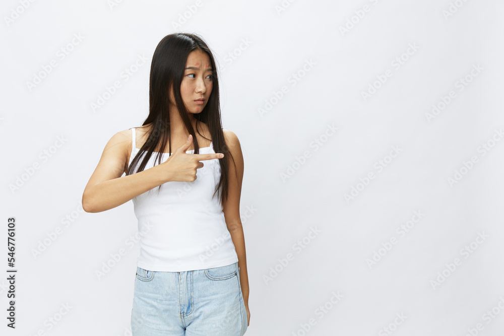 Asian woman hand signals, finger pointing facial skin problems, acne and inflammation, red rash and allergies, chicken pox, sadness from rashes. Facial skin care concept for diseases and nerves Asian woman hand signals, finger pointing facial skin problems, acne and inflammation, red rash and allergies, chicken pox, sadness from rashes. Facial skin care concept for diseases and nerves