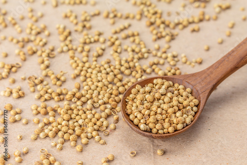 coriander seeds spoon on brown paper background.