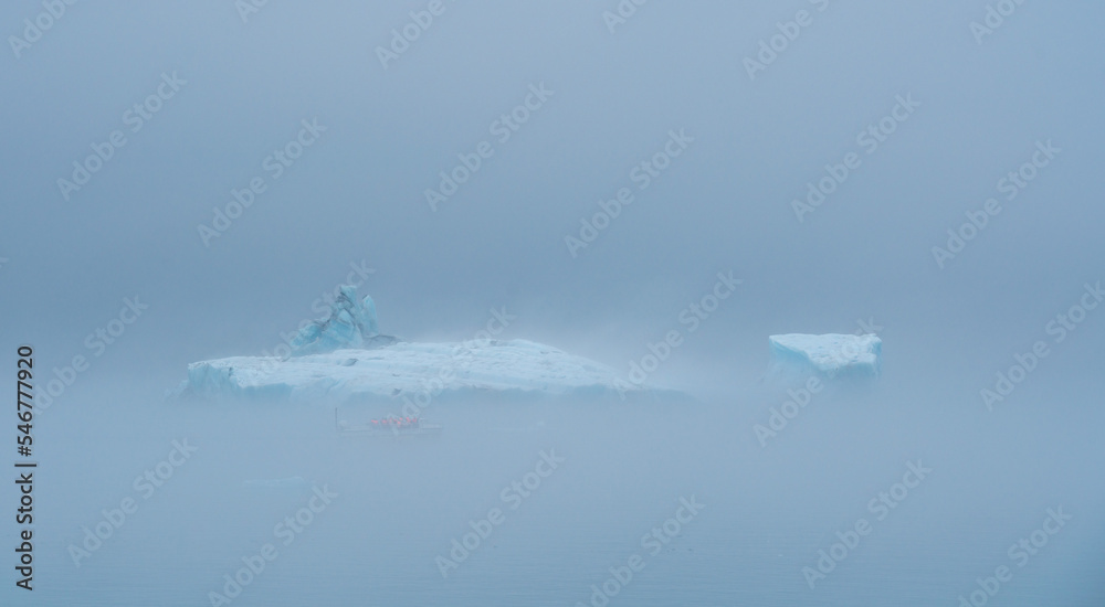 Icebergs floating in the ocean on a foggy day Icebergs floating in the ocean on a foggy day