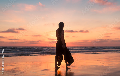 Woman silhouette walking during daydream sunset