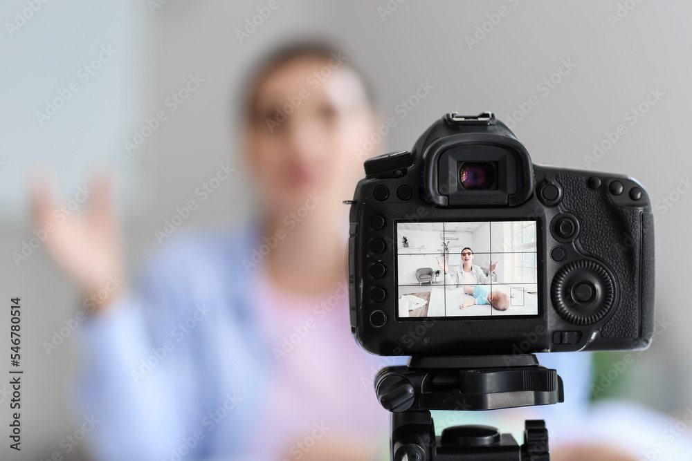 Young woman with little baby on screen of photo camera at home, closeup