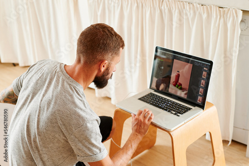 Photographer using a laptop for a shoot photo