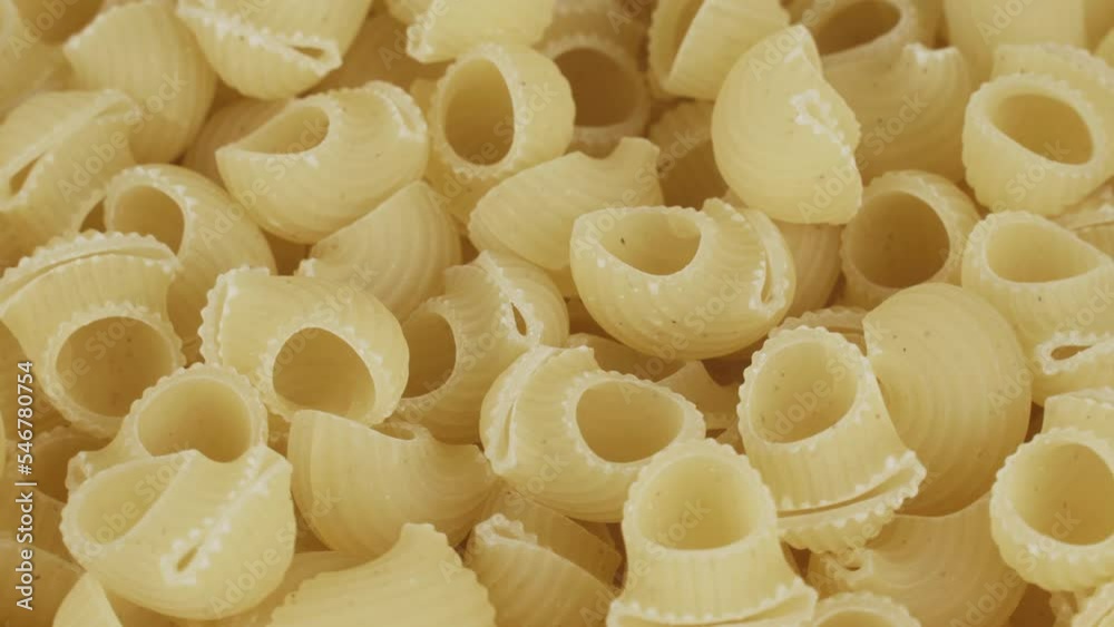 Raw pasta spins on a turntable. View from above. Food background. Raw pasta spins on a turntable. View from above. Food background.