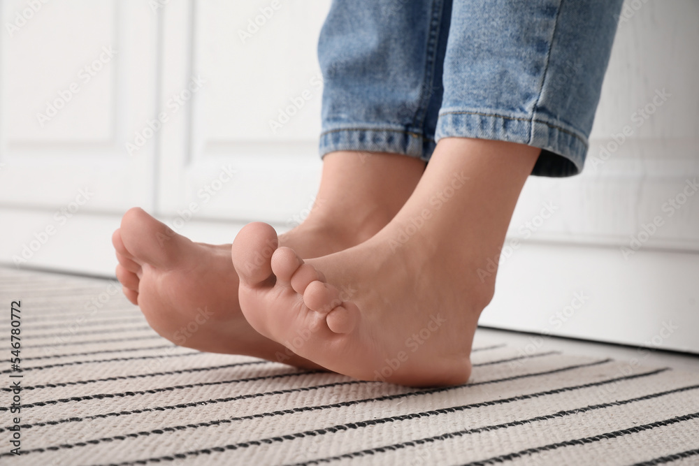 Female bare feet on striped carpet, closeup Female bare feet on striped carpet, closeup