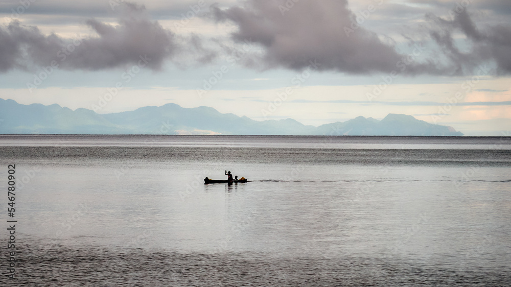 Woman, child paddling a dugout canoe silhouette, Savo, Pacific Islands Woman, child paddling a dugout canoe silhouette, Savo, Pacific Islands