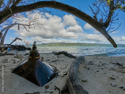 Old TV television tube discarded on tropical beach photo