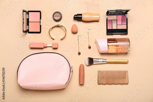 Pink bag with cosmetics and accessories on beige background