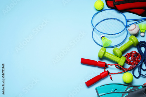 Set of different sports equipment on light blue background, flat lay. Space for text photo