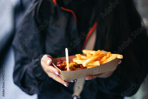 Unrecognizable person eating currywurst in Berlin photo