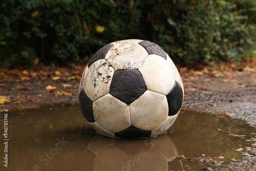 Dirty soccer ball in muddy puddle outdoors © New Africa