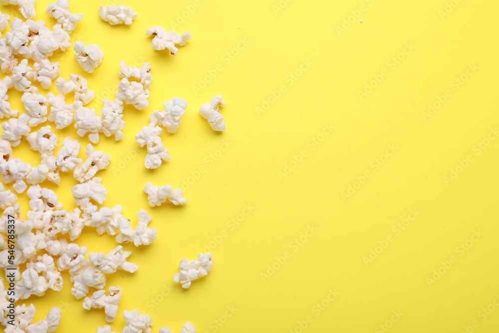 Fototapeta premium Tasty pop corn on yellow background, flat lay. Space for text