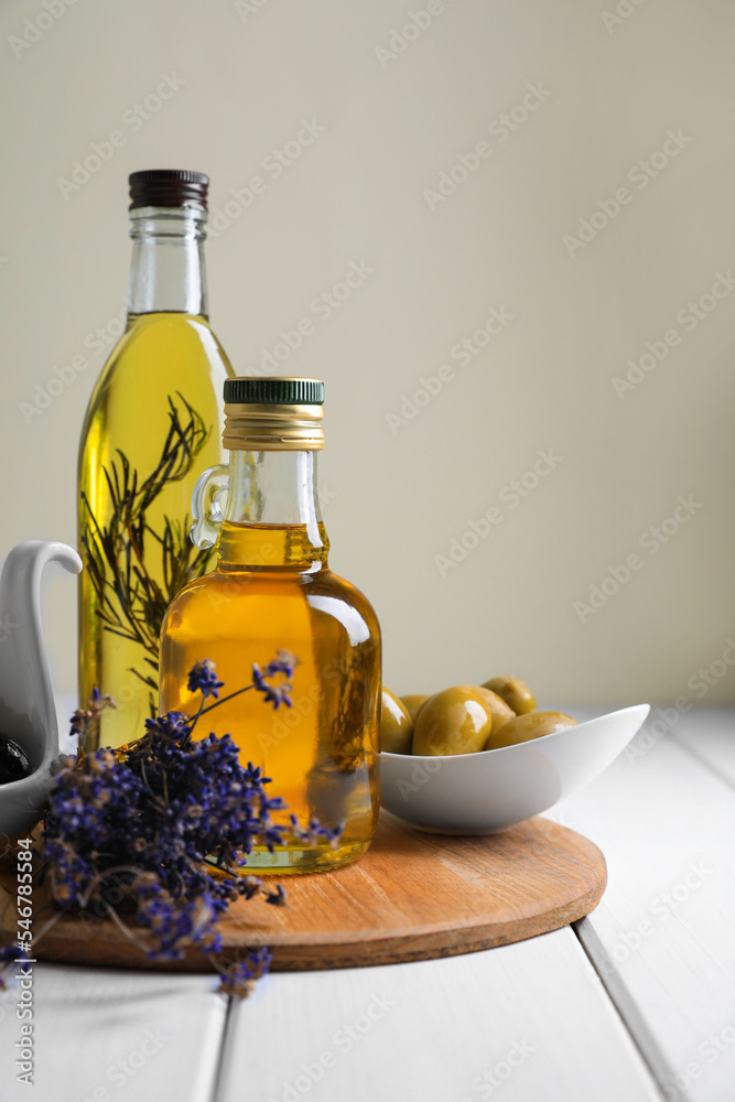Different cooking oils and ingredients on white wooden table against light background Different cooking oils and ingredients on white wooden table against light background