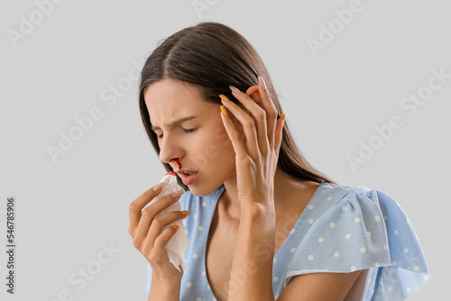 Young woman with nosebleed ...