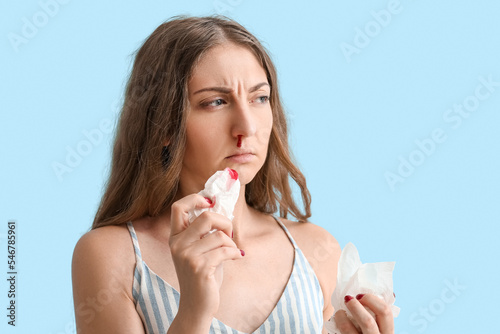 Young woman with nosebleed ...