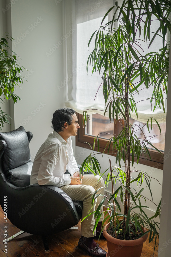 pensive man at home looking out the window pensive man at home looking out the window