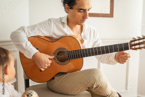 man playing guitar at home photo