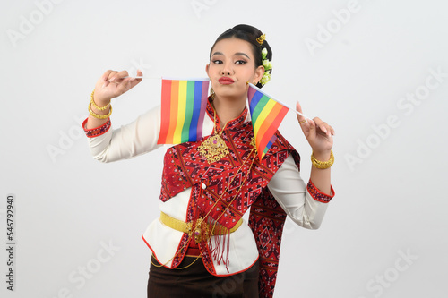 Portrait of Young woman in Thai Northeastern Traditional Clothing holding rainbow flag