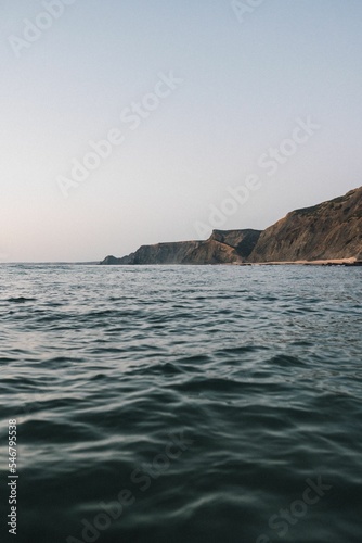 Vertical shot of hills of Praia da Cordoama against a sea in Portugal photo