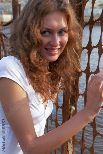 Youbg laughing woman near grid fence photo