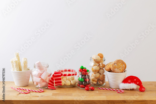 Print op canvas christmas candies and cookies  in jars on wooden shelf on white background
