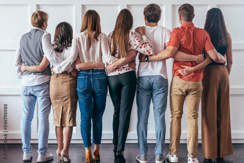 Fototapeta premium Group of young people hugging together Rear view