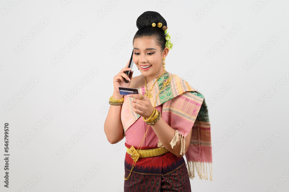 Young beautiful woman in northeastern dress use smartphone and credit card posture Young beautiful woman in northeastern dress use smartphone and credit card posture