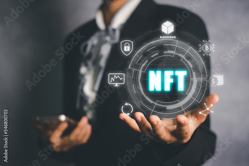 NFT token digital crypto art blockchain technology concept, Person hand holding virtual screen NFT icon background.