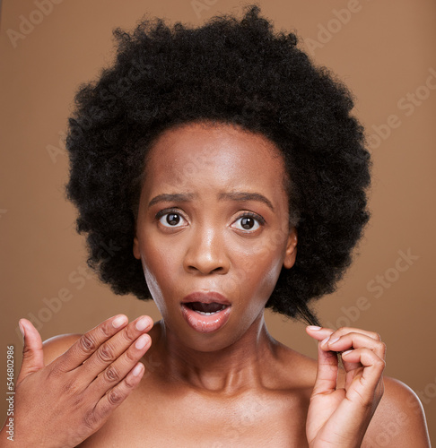 Hair, portrait and black woman in studio for problem, hair loss and hair care against a brown background. Face, model and afro hairstyle fail by woman confused, shocked and surprised by damaged hair