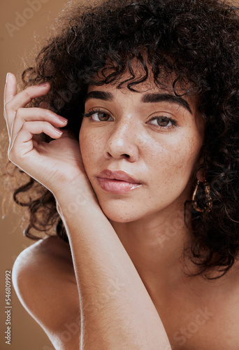 Skincare, hair care and face of woman with beauty, makeup and cosmetics against a brown studio background. Wellness, luxury and portrait of a girl model at a spa or salon for hair or natural skin