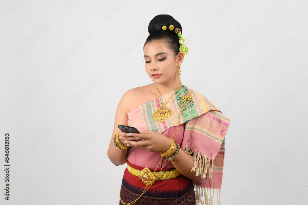 Young beautiful woman dress up in Thai northern region pose with smartphone Young beautiful woman dress up in Thai northern region pose with smartphone