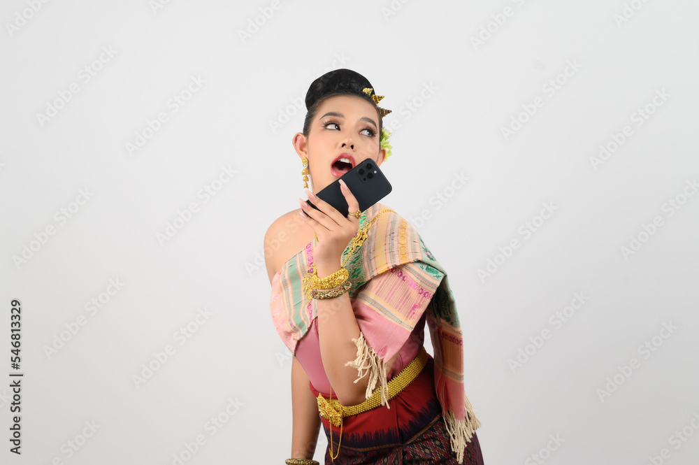 Young beautiful woman dress up in Thai northern region pose with smartphone