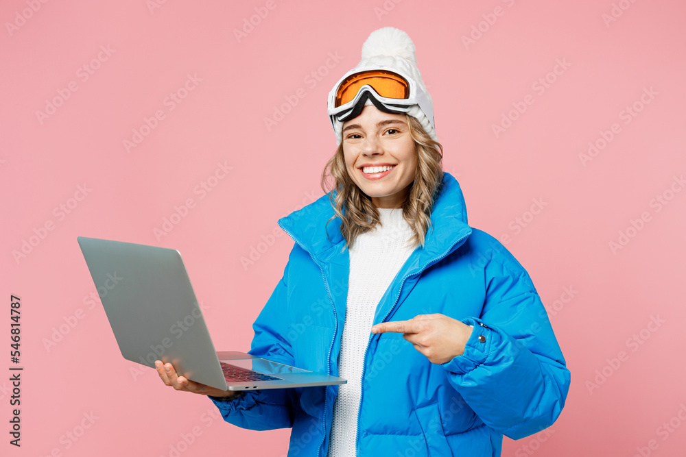 Snowboarder IT woman wear blue suit goggles mask hat ski padded jacket work use show laptop pc computer isolated on plain pastel pink background. Winter extreme sport hobby weekend trip relax concept. Snowboarder IT woman wear blue suit goggles mask hat ski padded jacket work use show laptop pc computer isolated on plain pastel pink background. Winter extreme sport hobby weekend trip relax concept.